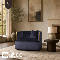 Fauteuil lounge moderne en tissu avec garniture en acier inoxydable 304, assise profondément rembourrée et accoudoirs arrondis pour salons de villas de luxe