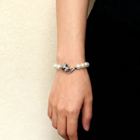Bracelet en perles blanches, fermoir léopard argenté rétro, détail œil vert, bijou de poignet tendance pour femme