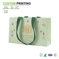 Sacs cadeaux vert sauge personnalisés avec monogramme doré et motif floral en relief pour la vente en gros de bijoux à Paris