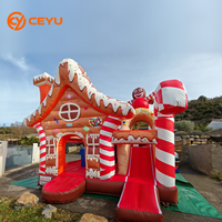 Château gonflable de Noël Ceyu en forme de maison de pain d'épices avec toit 3D, mascotte, piliers en forme de canne à sucre et entrée en forme de gable enneigé pour location événementielle