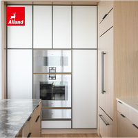 Meuble de cuisine Alland au design moderne avec portes de réfrigérateur encastrées, îlot cascade en chêne clair et étagères réglables