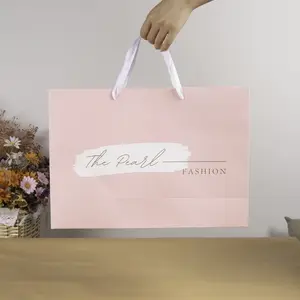 Sacchetto di carta per acquisti regalo basso all'ingrosso con Logo rosa personalizzato stampato piccoli sacchetti di carta artistica per piccole imprese con manici a nastro