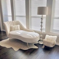 Fauteuil lounge élégant et moderne en velours et cuir avec pieds en métal doré, design incurvé unique et réglable pour la décoration du salon et de la chambre.