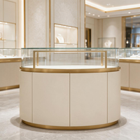 Vitrine à bijoux circulaire de luxe avec niches murales LED, sol en marbre, accents dorés, présentoir en verre, solution d'aménagement de boutique
