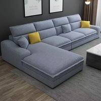 Canapé d'angle modulable beige en forme de L avec chaise longue, coussins à bordure côtelée en tissu et oreillers, idéal pour le salon