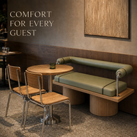 Ensemble de bancs vert sauge avec coussins et traverses, table ronde en bois avec chaises et tables sur piédestal pour restaurant, idéal pour café peu encombré