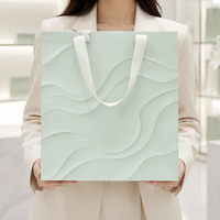 Sacs cadeaux personnalisés robustes et écologiques avec finition texturée 3D couleur menthe, logo gaufré à l'or et poignées en ruban pour emballage cadeau