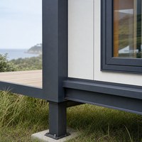 Maison conteneur préfabriquée compacte avec façade moderne, terrasse et aménagement jardiné