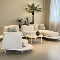 Ensemble de canapés d'extérieur modernes avec sièges arrondis et tables basses de forme originale
