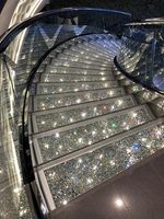 Escalier intérieur courbé artistique de luxe en promotion avec éclairage LED, marches en marbre et bois, et garde-corps en verre pour villa