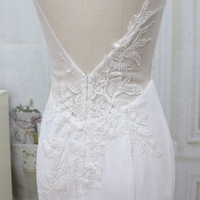 Robe de mariée sirène de luxe moderne, longueur ras du sol, bretelles spaghetti, dos illusion, détails boutonnés, appliques en dentelle perlée, lavable