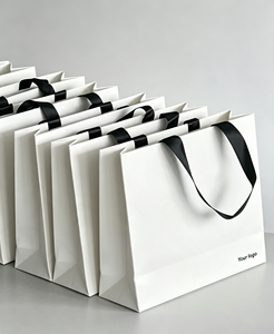 Sacs shopping en papier blanc avec logo personnalisé, poignées en ruban noir, design plat luxueux et recyclable pour l'emballage professionnel - Product Image 1