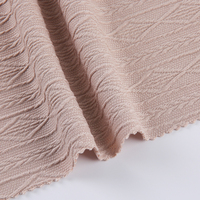 Tissu jacquard en polyester tricoté extensible, poids moyen 270 g/m², motif en forme de losange, lignes ondulées en V, 5 % élasthanne, 95 % polyester
