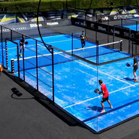 Terrain de padel avec murs en verre, maille métallique et éclairage pour complexes sportifs intérieurs