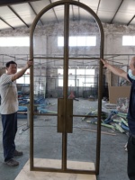Porte en verre gris avec poignées, cadre en acier massif à charnières, style industriel