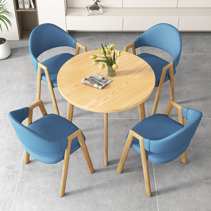 Une table et quatre chaises en couleur bois (chaises en tissu bleu)