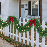 Guirlande de Noël artificielle en cèdre avec ornements dorés, nœud en velours rouge, et lianes de pin vertes sans neige pour la décoration des fêtes