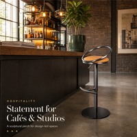 Tabouret de bar industriel avec assise en velours cognac, dossier en anneau métallique, repose-pieds en demi-lune gris anthracite, réglage en hauteur à vérin, pour la maison