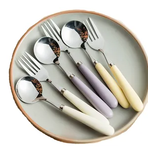 घरेलू रसोई नाश्ते के उपयोग के लिए सिरेमिक हैंडल के साथ स्टेनलेस स्टील रंगीन चम्मच और कांटा नॉर्डिक घरेलू फ्लैटवेयर सलाद कांटा