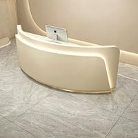 Bureau de réception incurvé minimaliste sur mesure avec base dorée et éclairage LED encastré pour salon de beauté, spa, clinique