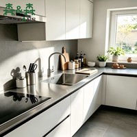 Meubles de cuisine minimalistes, portes en panneaux blancs mats, plan de travail noir, en forme de L, réfrigérateur intégré, sans poignées, ensemble de cuisine sur mesure