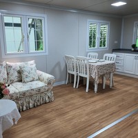 Maison conteneur extensible à bordure blanche 20 pieds, toit à pignon, couleur crème, 2 chambres, fenêtres à grille, porche, terrasse, cabane entièrement équipée
