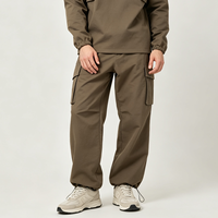 Pantalon cargo homme olive foncé à jambe large, poches à rabat, cordon de serrage à la cheville, revers ajustables, fermeture éclair discrète, style Techwear Urbain et Extérieur