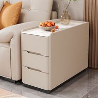 Une petite table de chevet intelligente avec une sensation de double couche, dotée d'un placard latéral de luxe léger, d'une plaque en pierre, d'un sol en cuir et de roulettes