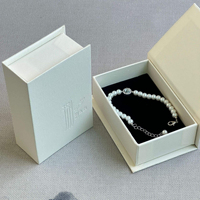 Boîte à bijoux rigide beige en forme de livre avec fermeture magnétique pour la personnalisation de colliers de luxe et la vente au détail professionnelle en boutique