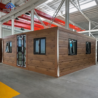 Maisonnette modulaire préfabriquée à double aile en grain de bois avec fenêtre à auvent, porte pliante en verre, cabane forestière, villa, entrepôt extensible en acier