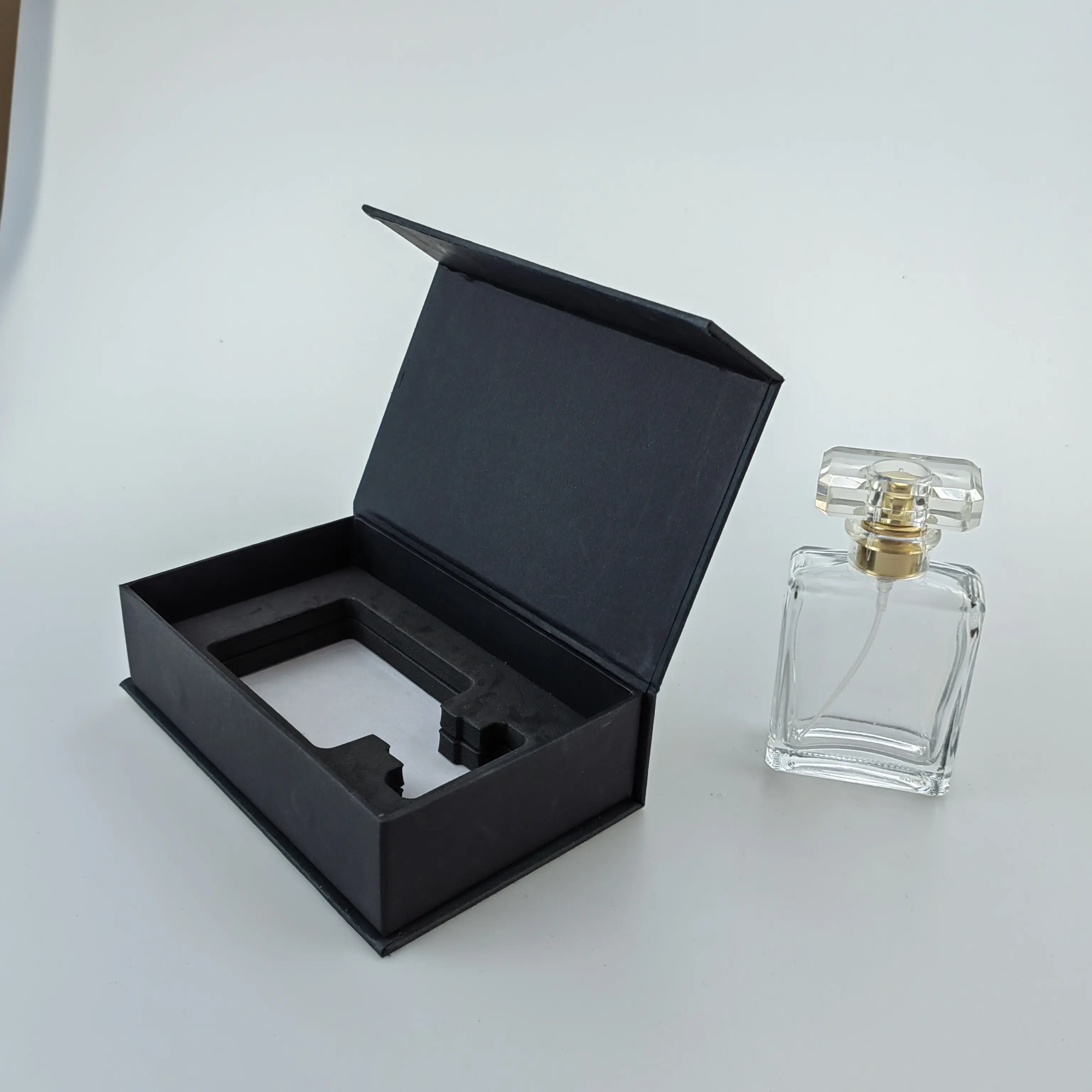 Kotak kemasan kotak hadiah Kit perawatan kardus bentuk buku hitam dengan sisipan busa penutupan magnetis kustom