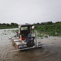Machine de récolte amphibie multifonctionnelle avec accessoires de coupe de roseaux pour zones humides et lacs.