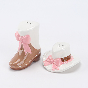 Ensemble salière et poivrière en céramique style western, en forme <span class=keywords><strong>de</strong></span> bottes et <span class=keywords><strong>de</strong></span> chapeaux, blanc avec nœuds roses et accents marron, thème <span class=keywords><strong>cowboy</strong></span> amusant pour les condiments - Product Image 1