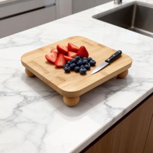Square bamboo cutting board elevated on four rounded ball feet