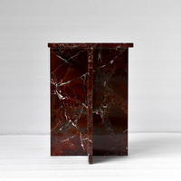 Table basse élégante en marbre scandinave bordeaux, sculpturale avec cadre en X, accent en pierre rouge profond, mobilier haut de gamme pour salon