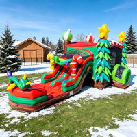 Structure gonflable de Noël avec double toboggan et parcours d'obstacles pour enfants, idéale pour la location commerciale, les fêtes et les événements en extérieur