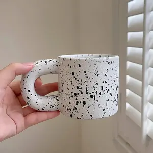 Caneca de café preto e branco com alça grossa, xícaras de café de cerâmica, copos de água com bolinhas irregulares