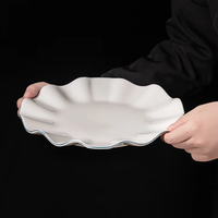 Nouveauté 2025, assiettes à dîner de forme irrégulière, design de bord bleu, émail blanc, assiette de service en céramique à volants pour mariage, événement