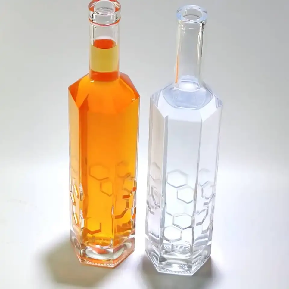 Botella de vidrio decorada con miel hexagonal al por mayor de fábrica con patrón de diseño de panal