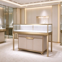 Comptoir de présentation de bijoux en verre avec cadre doré et armoire de rangement en similicuir pour la vente de bijoux de luxe