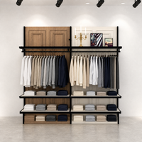 Porte-vêtements commercial en métal noir avec panneau arrière en bois bicolore blanc et étagères doubles suspendues