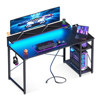Bureau de jeu compact en fibre de carbone noir avec prises de courant réglables, support d'ordinateur LED en forme de L, étagères réversibles et design d'angle