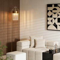 Lámpara de pie moderna con marco de latón y pantalla cilíndrica de cristal blanco, iluminación minimalista para decoración de habitaciones de hotel.