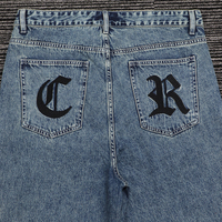 Shorts en denim sergé 100 % coton 13 oz, taille mi-haute, délavage pierre, effet whiskers, coupe ample, avec broderie gothique épaisse sur les poches arrière
