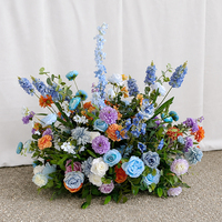 Décoration florale de scène pour mariage : Grande rangée de fleurs bleues, oranges et violettes pour toile de fond de scène