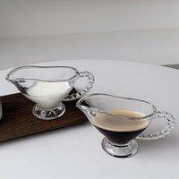 Carafe à crème en verre transparent avec poignée perlée et base sur pied, verseuse à lait pour le service de café et de thé sur table