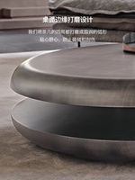Table basse rotative à double niveau en acier inoxydable, design italien, style minimaliste et artistique, pour salon de luxe.