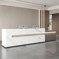 Comptoir de réception moderne personnalisé avec effet marbre et éclairage LED pour hôtel, immeuble commercial, hall d'entreprise