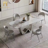 Table à manger de luxe avec plateau en pierre, base profilée et pieds incurvés au design créatif pour mobilier de salle à manger
