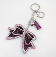 Koningsblauwe modieuze sleutelhanger met zwarte achtergrond, strikvorm, volledig bezet met strass steentjes en kwastjes, best verkochte charme hangende ornament